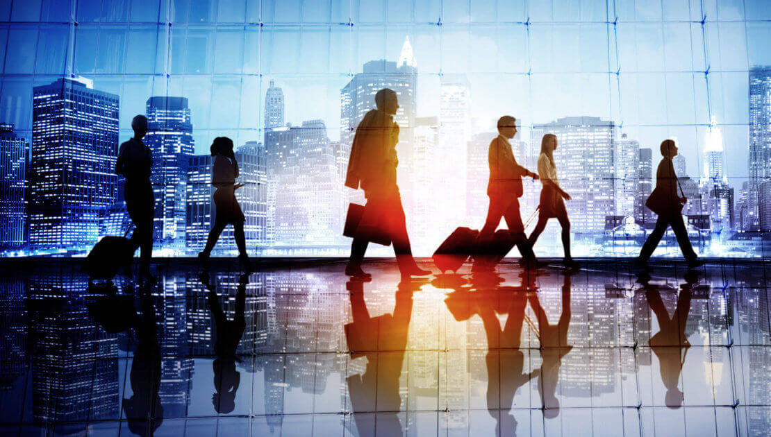 Silhouettes of people walking in urban setting.