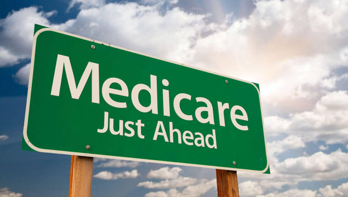 Green Medicare sign under cloudy sky.