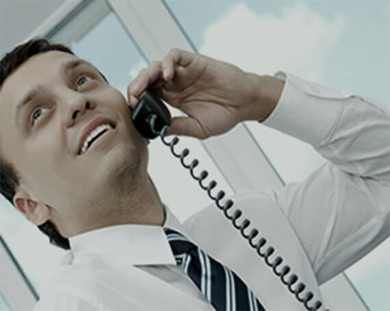Man smiling while talking on the phone.