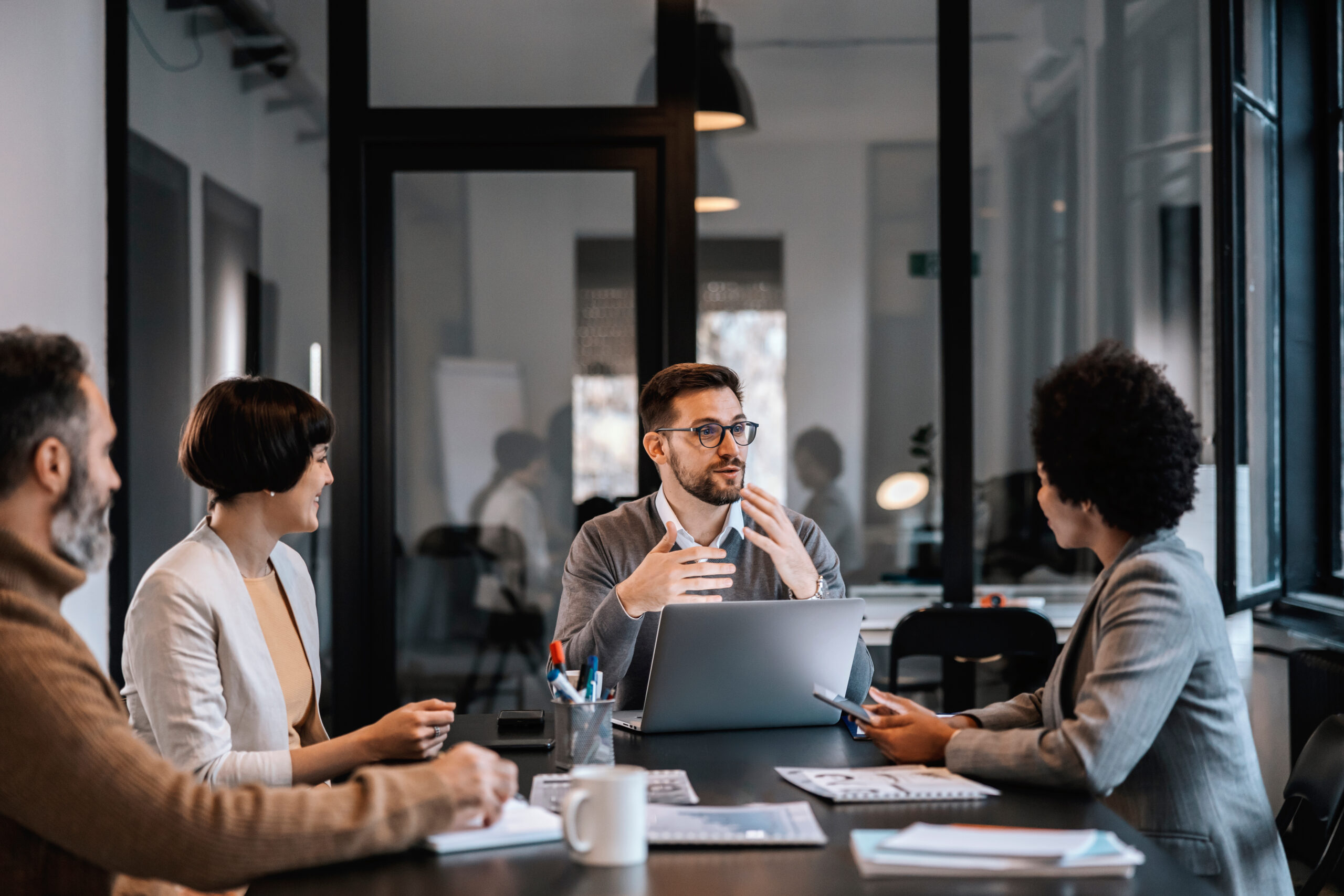 Business meeting with four people discussing.