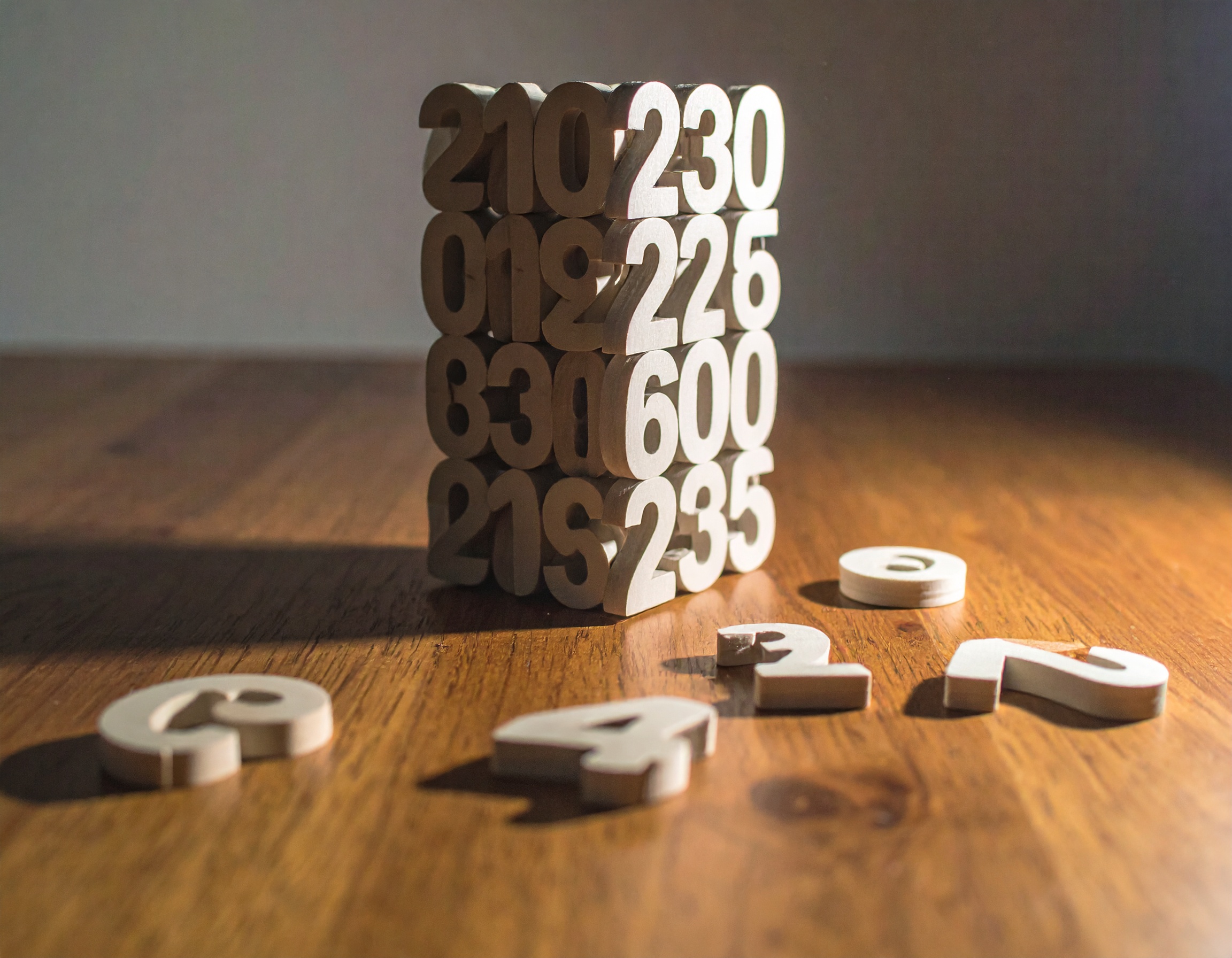 Stacked number blocks on wooden table.