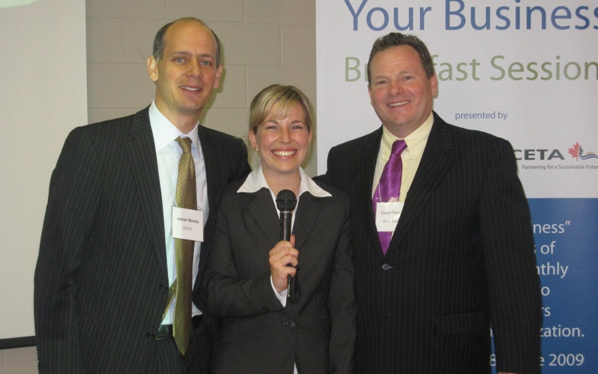 Three people smiling at business event.