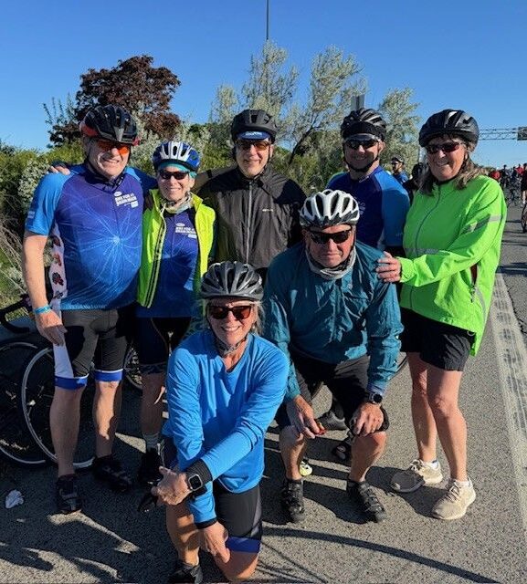 Group of cyclists posing together outdoors.