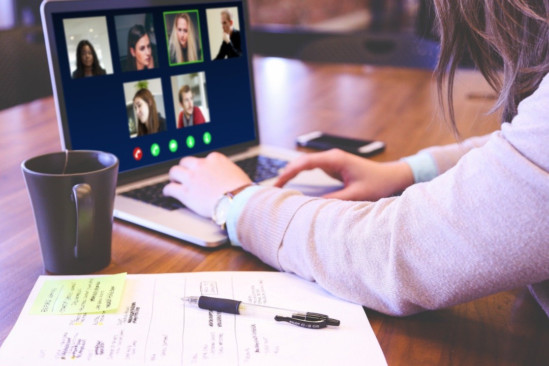 Person attending virtual meeting on laptop.