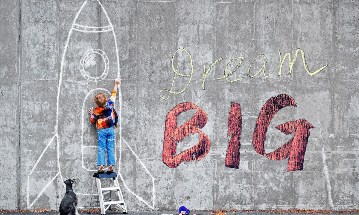 Child drawing rocket, "Dream Big" on wall.